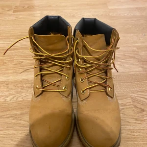 Bruna boots från Timberland - Säljer ett par klassiska bruna Timberland boots med snörning och robust sula. Perfekta för höst och vinter med sin slitstarka design och bekväma passform.