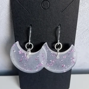 Egentillverkade örhängen  - Egentillverkade örhängen gjorda i transparent resin med lite skimmer i och lila folie. Öronkroken är gjord av plast. Längd ca 2.7cm 