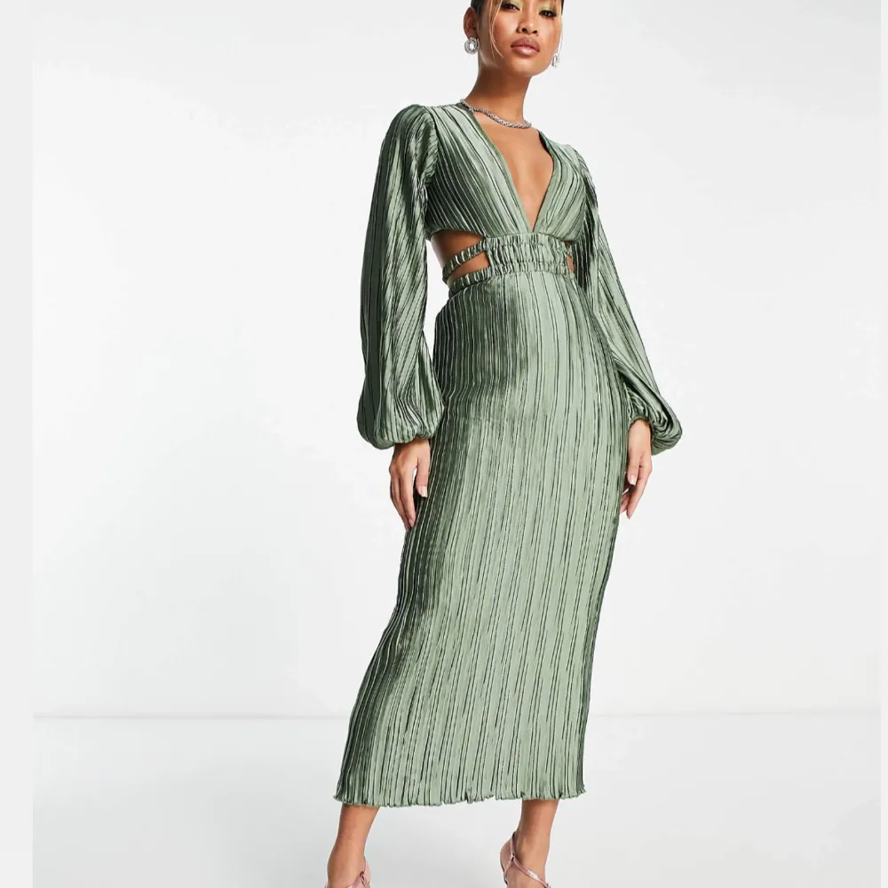 Beställde fel storlek och hann inte returnera den till ASOS. Elegant grön långklänning med puffiga långärmar. Klänningen har en ribbad struktur och utskärningar i midjan. Helt oanvänd med prislapp kvar. Fin till examen eller bröllop. Slutsåld på hemsidan.. Mekot.