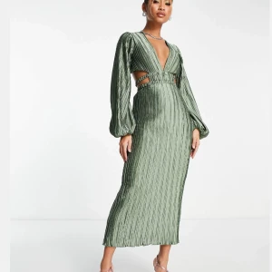 Salviagrön midiklänning - Beställde fel storlek och hann inte returnera den till ASOS. Elegant grön långklänning med puffiga långärmar. Klänningen har en ribbad struktur och utskärningar i midjan. Helt oanvänd med prislapp kvar. Fin till examen eller bröllop. Slutsåld på hemsidan.