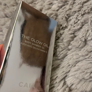 The Glow Oil från CAIA - The Glow Oil från CAIA är en kroppsolja med skimmer, berikad med avokadoolja och vitamin E. Förpackningen är elegant och reflekterande, vilket ger en lyxig känsla.helt oanvänd limiterad 