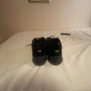 Svarta Nike Vapormax sneakers - Säljer ett par svarta Nike Vapormax sneakers med unik sula och snörning. Perfekta för en sportig look.