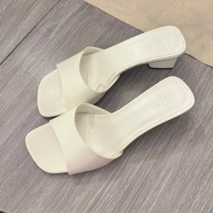 Vita sandaler från Zara - Stilrena vita sandaler från Zara med en fyrkantig tå och låg klack. Perfekta för en elegant look.