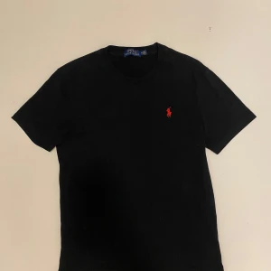 Svart Ralph Lauren t shirt - svart t-shirt från Polo Ralph Lauren i väldigt bra skick använd Max 3 gånger. Perfekt för en stilren look. Kortärmad och tillverkad i mjukt material för extra komfort. Perfekt julklapp🎁 Skriv vid minsta fråga eller fundering🔥👍