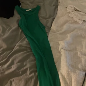 Grön ärmlös klänning - Snygg grön ärmlös klänning i ett mjukt material. Perfekt för varma dagar med sin enkla och stilrena design.