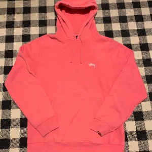 Stüssy Stock Logo Hoodie - Rosa Stüssy hoodie i storlek Large. Använd men ändå hyfsat bra skick. Den har en liten fläck i fram (sista bilden). Skriv gärna vid frågor eller prisförslag!