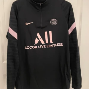 Fotbollströja  - Snygg svart långärmad fotbollströja från Nike med rosa detaljer och PSG-logga.