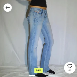 Ljusblå jeans med broderade fickor - Snygga ljusblå jeans med bootcut-stil och broderade detaljer på bakfickorna. De har en lågmidjad passform och är från Miss softy. Midjemått 36cm och innerbenslängd 75cm. 
