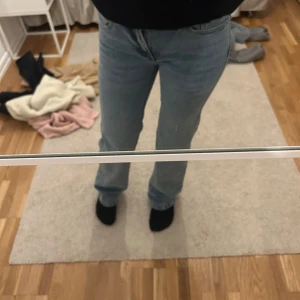 Blå jeans från 157 - Säljer ett par klassiska blå jeans från 157 med bootcut-stil. De är low waist och är perfekta för en avslappnad look. Jeansen har fem fickor och stängs med dragkedja och knapp.