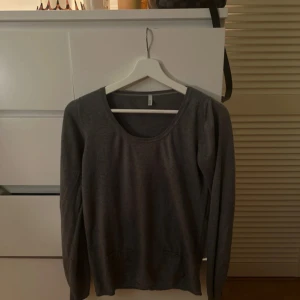 Grå tröja från Benetton - Säljer en stilren grå tröja från Benetton. Tröjan har långa ärmar och en rund halsringning. Den är tillverkad i ett cashmere som är mjukt och bekvämt, och har dekorativa knappar på framsidan. Perfekt för en avslappnad look. Går ej att köpa längre då den är från 2010 💗💗