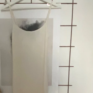 Beige soft touch långklänning med smala axelband - Beige långklänning med smala axelband och en figurnära passform. Aldrig kommit till användning för mig