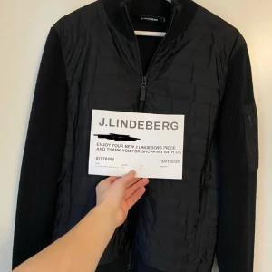 Svart quiltad jacka från J.Lindeberg - Intressekoll!! Snygg svart quiltad jacka från J.Lindeberg med dragkedja framtill. Jackan har ribbade ärmslut och krage, samt en praktisk ficka på ärmen. Perfekt för en stilren look.