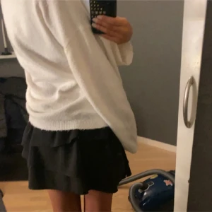 Svart volangkjol från H&M - Säljer en svart volangkjol från H&M i storlek M. Kjolen har flera lager med volanger och en elastisk midja för en bekväm passform. Perfekt för att ge en trendig touch till din outfit. Inga defekter. Sitter som en S