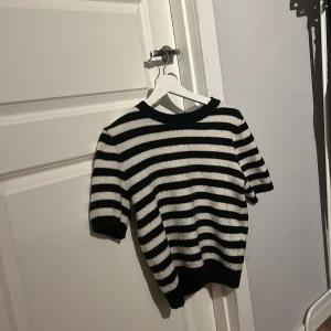 Randig tröja från H&M - Säljer en svartvit randig tröja från H&M. Tröjan har trekvartsärmar och en bekväm passform. Perfekt för en avslappnad stil.