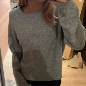Grå stickad tröja - Mysig grå stickad tröja med rund hals och långa ärmar. Perfekt för kyliga dagar och enkel att matcha med olika outfits. Helt oanvänd förutom på bild. Är storlek L men sitter som S