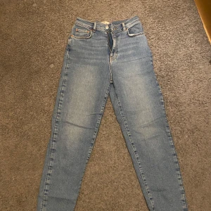 Blå jeans från Gina Tricot  - Snygga blå jeans från Gina Tricot i storlek 36. Klassisk design med fickor och knappgylf. Straight jeans.