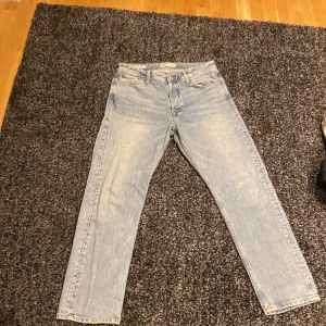 Ljusblå jeans från Jack & Jones - Säljer ett par ljusblå jeans från Jack & Jones i modellen Loose/Chris. De har en avslappnad passform och klassisk femficksdesign. Perfekta för en casual look!