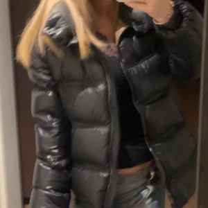 Svart pufferjacka - Säljer en svart pufferjacka med huva. Jackan har en dragkedja framtill och är perfekt för kyligare väder. Den är vadderad och ger en skön och varm känsla. Passar bra till vardagsoutfits. I ny skick, säljer pgd av vill ha en annan💕💕