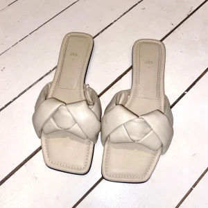 Beige sandaler från Zara - beige sandaler från Zara med flätad detalj över foten. I storleken 38.