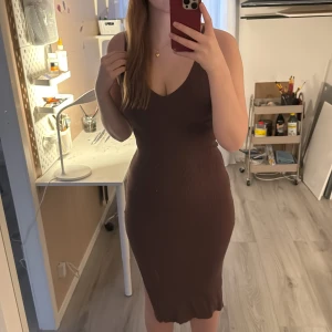 Brun ribbad klänning - brun ribbad klänning med v-ringning och slits på sidan. Från Gina i storlek s, knappt använd, inga defekter eller liknande