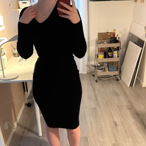 Svart klänning med osymmetrisk v-ringning - svart klänning med osymmetrisk v-ringning och långa ärmar. Klänningen har en tight passform och en liten slits på sidan. Från bikbok i storlek s. Använd 2 gånger innan, inga defekter eller liknande. Nypris 500