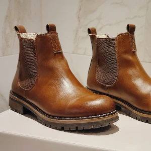 Chelsea boots bruna - Bruna vinterkängor med fluffig fodrad insida. Skickas eller hämtas i Uppsala.