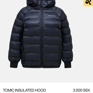 Svart pufferjacka från Peak Performance - Säljer en svart pufferjacka från Peak Performance med huva och dragkedja. Jackan är perfekt för kyliga dagar och har en stilren design. Den är långärmad och har en isolerad konstruktion för extra värme. Köpt i slutet av förra vinter och hann knappt bli andvänd säljer för har köpt en ny då denna blev för lite 