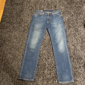 Levi's 511 blå jeans - Säljer ett par klassiska Levi's 511 blå jeans. De har en slimfit passform och är tillverkade i slitstarkt denim. Perfekta för en avslappnad stil med fem fickor och knappgylf.