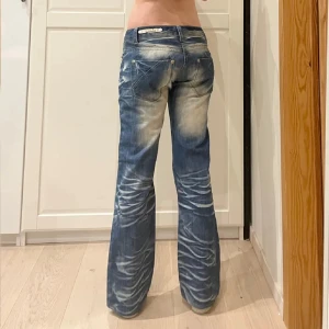 Blå bootcut jeans - Snygga blå bootcut jeans med en cool tvättad look. De har låg midja. Jätte fina och i bra skick de passade bara inte mig så säljer vidare💕 lånade bilder. Midja: 42cm.   gren: 19cm. innerben:76cm.   hon på bilden är 169cm