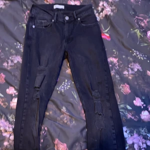 Svarta jeans från No Religion - Snygga svarta jeans från No Religion med slitna detaljer. Har en snygg design till sig. köpta för 550kr. Säljer de då jag växt ur de 