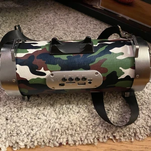Camouflage mönstrad högtalare - Snygg och bärbar högtalare med ett coolt camouflage mönster. Perfekt för att ta med på äventyr eller bara ha hemma. Utrustad med flera anslutningsmöjligheter och ett praktiskt bärhandtag.funkar jättebra 