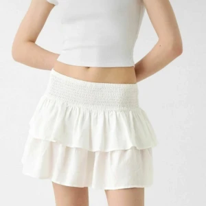 Vit volangkjol - Söt vit kortkjol från zara med volanger och elastisk midja. Perfekt för en somrig look. Kjolen har en luftig och bekväm passform.