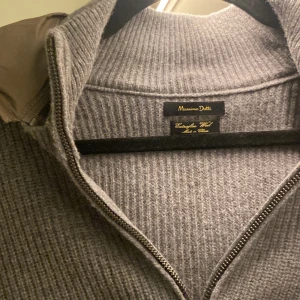 Massimo Dutti Grå stickad cardigan - Snygg grå stickad cardigan från Massimo Dutti med dragkedja och huva. Fint skick och i storlek L men passar även en stor M. Cardiganen säljs inte längre på deras hemsida