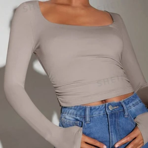 Beige långärmad topp  - Snygg beige långärmad topp i ett mjukt och stretchigt material. Den har en tight passform och en stilren design som gör den lätt att matcha med olika outfits. Använd endast 1 gång. 