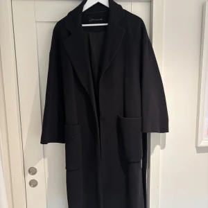 Svart kappa med bälte - Säljer min svarta kappa från Zara🖤 Lite nopprig men annars i bra skick!