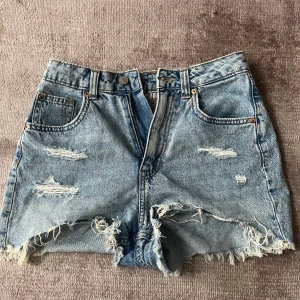 H&M - mid waist jeansshorts  - Blå/ ljusblå jeans shorts med hål  Mycket bra skick  