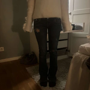 Mörkblå jeans med slitningar - As snygga mörkblå jeans som har slutat säljas, lågmidgade och bootcut med slitningar som är jätte snygga. Pris kan diskuteras och skriv för fler bilder❤️❤️jag är 162cm❤️har sytt om jeansen själv till lågmidjade❤️❤️