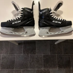 Svarta CCM skridskor - Säljer ett par svarta CCM skridskor i mycket bra skick (endast använda 1 vinter och isen varade typ i en vecka). De har en snygg design med vita snören och  en robust konstruktion. Perfekta för vinterns isäventyr! Storlek US 9, vilket motsvarar herr 44 i EU-storlek. 