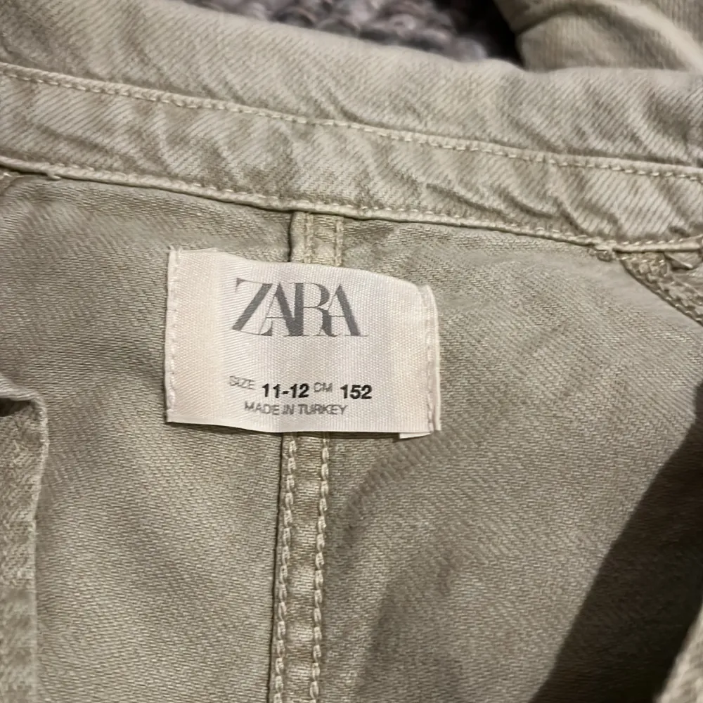 Säljer en snygg beige jacka från Zara i storlek 11-12 år. Jackan har en croppad stil med knappar framtill och två praktiska fickor. Perfekt för vår och höst! 🧥. Takit.