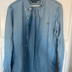 Jeans skjorta från Polo Ralph Lauren - Säljer en snygg jeans skjorta från Polo Ralph Lauren i slim fit. Skjortan är långärmad och har klassiska knappar framtill. Perfekt för både vardag och fest! 💙