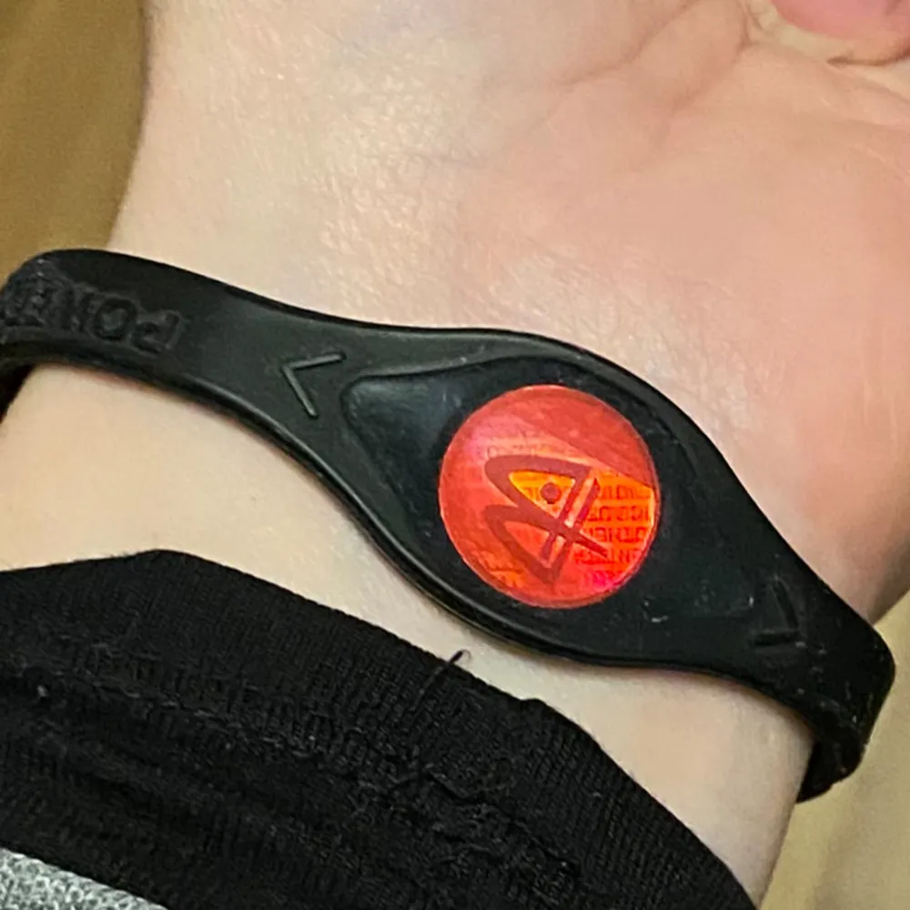 Power Balance-armband. Aldrig använt.   Power Balance- armbandet har två hologram, en på vardera sidan av armbandet. Hologrammen är designade för att 