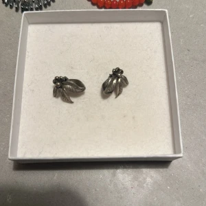 Söta silverfärgade örhängen clips  - Säljer ett par söta örhängen i form av små blommor i silverfärg. De har en fin detalj med små pärlor i mitten som ger en elegant touch. Perfekta för både vardag och fest! 🌸