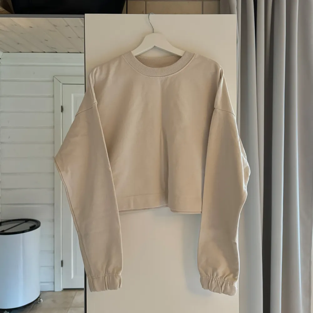 En krämvit/beige croppad sweatshirt från H&M. Aldrig använd.🥰. Hoodies.