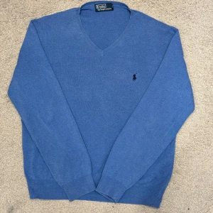 Blå V-ringad Tröja från Polo Ralph Lauren - En riktig snygg tröja som har 2 väldigt små fläckar som knappt syns (se sista bilderna)