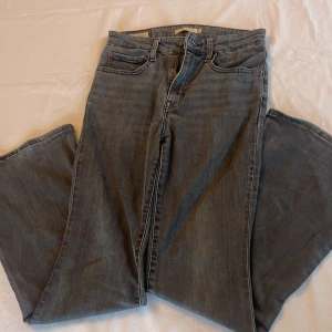 Mörkgråa Levis jeans - Säljer ett par jättefina mörkgråa flare jeans från Levis. De sitter högt i midjan och de är relativt stretchiga. 