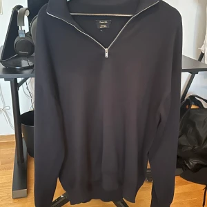 Mörkblå tröja med dragkedja från Massimo Dutti - Säljer en stilren mörkblå tröja från Massimo Dutti i storlek S. Tröjan har en dragkedja vid halsen och är perfekt för både höst och vinter. Den är långärmad och gjord i ett mjukt material som känns skönt mot huden. Passar både till vardags och lite finare tillfällen. (Den är knappast andvänd)