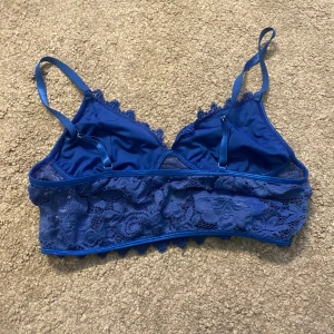 Blå spets bralette - Snygg blå BH i spets med justerbara axelband. Bekväm att ha på sig och sitter på plats hela dagen. Den har en fin spetsdesign. Passar bra under en genomskinlig topp eller som vanlig HB