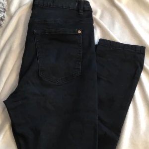 Svarta jeans från LAB Industries - Säljer ett par svarta jeans från LAB Industries i storlek 170. De har en snygg slitning på knäna och är gjorda av hållbart denim. Perfekta för en cool och avslappnad stil. Passar både till vardags och fest! Ställbara i midjan. 