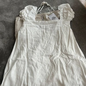 Vit klänning från Princess Polly - vit klänning från Princess Polly i storlek 2. Den har puffiga kortärmar och en fyrkantig urringning. Perfekt för sommardagar eller en avslappnad fest, eller till studenten som jag tänkte men hittade en annan till . Materialet känns lätt och luftigt, vilket gör den idealisk för varma dagar. Klänningen är i nytt skick och kommer med originalförpackning.