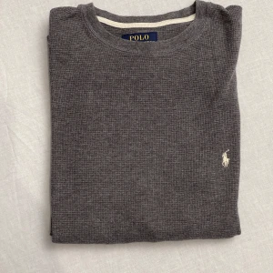 Riktigt snygg crewneck från Polo Ralph Lauren - Säljer en riktigt stilren grå crewneck från Polo Ralph Lauren i 100% bomull. Den har en klassisk design med långärmade ärmar och en broderad logga på bröstet. Perfekt för både vardag och lite finare tillfällen. Superbekväm och lätt att matcha med det mesta i garderoben! Strl S